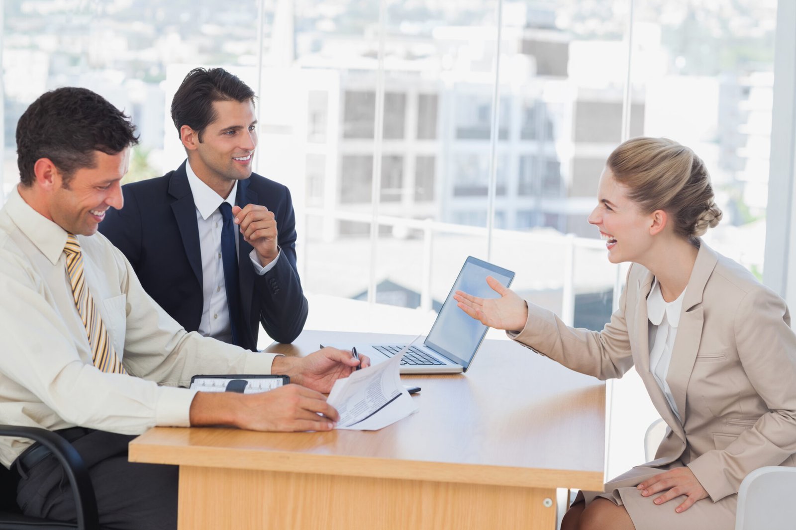 Business people laughing with interviewee in office